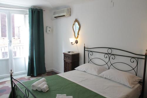 una camera da letto con un letto con una coperta verde e una finestra di La Giara a Palermo