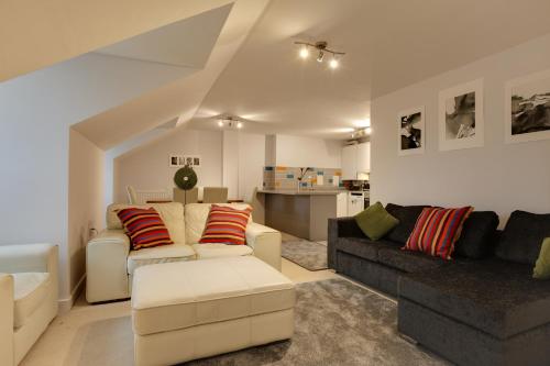 a living room with a couch and a table at Modern Spacious Apartments in Bishops Stortford