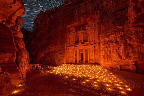 a large cave with lights in front of a building at Petra Main Gate Studios in Wadi Musa