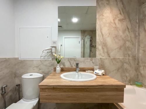 La salle de bains est pourvue d'un lavabo, de toilettes et d'un miroir. dans l'établissement HiGuests - Amazing Sea Views from this 2BR Apt in JBR, à Dubaï