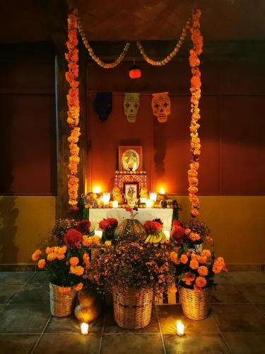 a altar with flowers and candles in a room at Casa Donaji in Oaxaca City