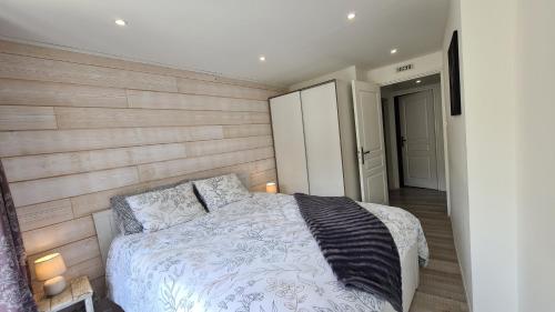 Serre Chevalier, Superbe appartement 5/7 couchages في سا شيفري: غرفة نوم بسرير وجدار خشبي