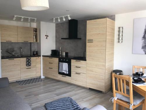 une grande cuisine avec des placards en bois et une table dans l'établissement Serre Chevalier, Superbe appartement 5/7 couchages, à Saint-Chaffrey