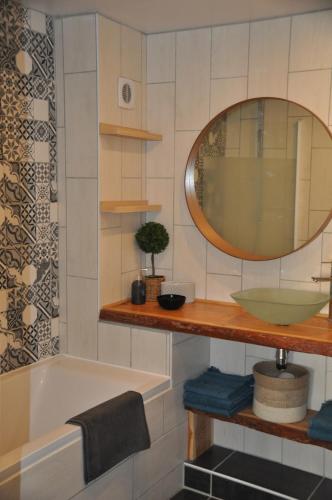 a bathroom with a tub and a sink and a mirror at Serre Chevalier, Superbe appartement 5/7 couchages in Saint-Chaffrey