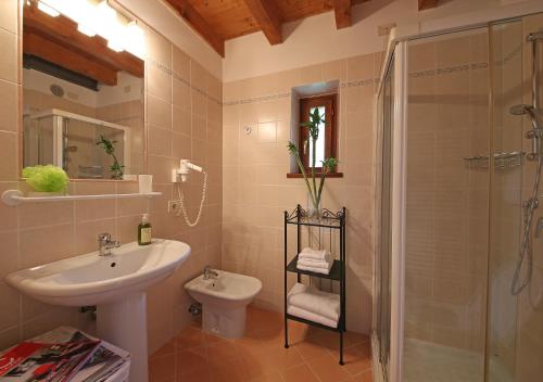 a bathroom with a sink and a toilet and a shower at Residence Fondo La Campagnola in Gargnano
