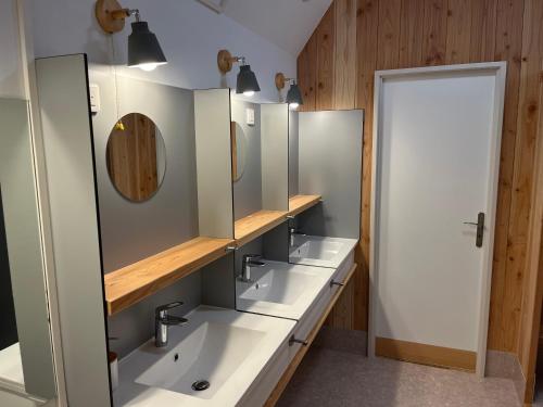 een badkamer met 3 wastafels en een spiegel bij L'Ermitage in Annonay
