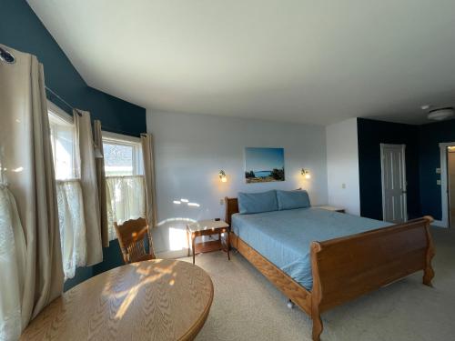 a bedroom with a bed and a table at The Edenwild Boutique Inn in Lopez