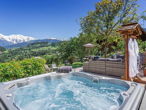a jacuzzi tub in a backyard with a couch at CHALET LES CERISES Jacuzzi, Sauna, Hammam, Cinéma in Cordon