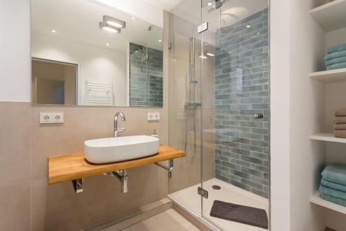 a bathroom with a sink and a shower at Lieblingshome in Tinnum