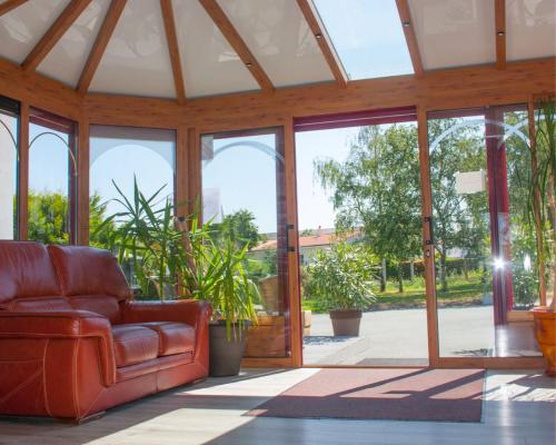 a living room with a couch and glass doors at Domaine du Bocage in Chavagnes-en-Paillers