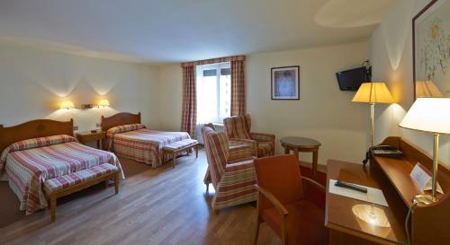 Una habitación de hotel con una cama y una sala de estar. en Hotel Abat Cisneros Montserrat, en Montserrat