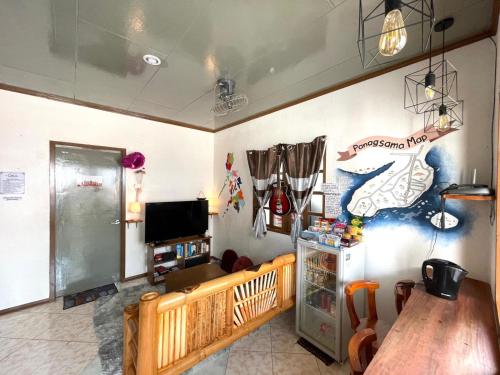 a living room with a table and a tv at Ohlala Hostel in Moalboal