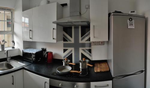 eine Küche mit weißen Schränken und einer schwarzen Arbeitsplatte in der Unterkunft Location Location Location, Whole apartment for you! in London