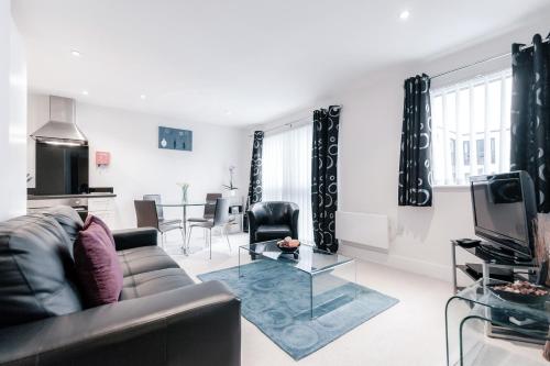 a living room with a couch and a table at Roomspace Serviced Apartments - Capitol Square in Epsom