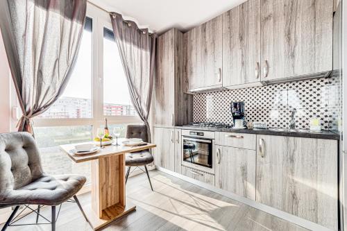 a kitchen with wooden cabinets and a table and chairs at ARI Brownie Apartment in Arad