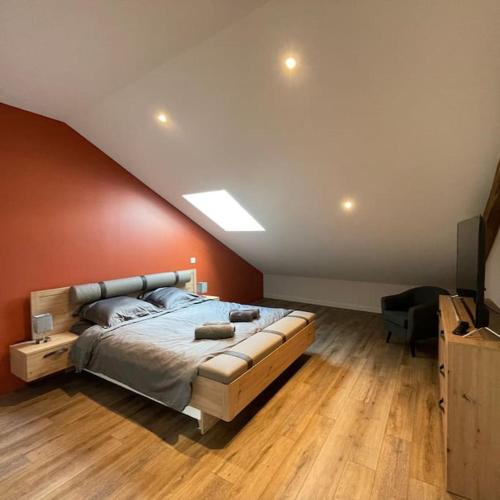 une chambre avec un grand lit et un mur rouge dans l'établissement Escale en Champagne, à Proverville