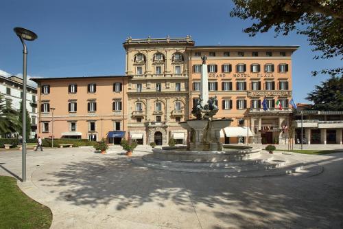 a large building with a fountain in front of a building at Grand Hotel Plaza & Locanda Maggiore in Montecatini Terme