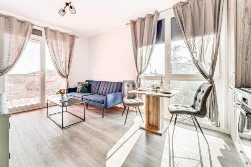 ein Wohnzimmer mit einem Sofa, Stühlen und Fenstern in der Unterkunft ARI Brownie Apartment near AFI Mall in Arad