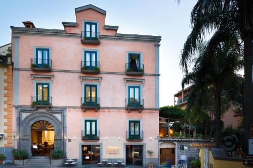 a large pink building with windows and plants at Palazzo Marziale in Sorrento