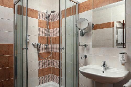 a bathroom with a shower and a sink at Golf & Spa Kunětická Hora in Dritec