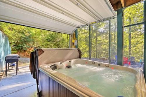 eine Whirlpool-Badewanne in einem Haus mit Fenstern in der Unterkunft Custom-Built Luxury Cabin with Tesla Charger! in Ellijay