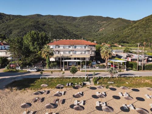a group of birds sitting on the sand in front of a building at Calma Beach Hotel in Stavros