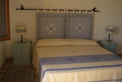 a bedroom with a bed with two night stands and two lamps at B&B Pubulos in Olbia