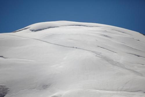 a snow covered mountain with a person walking on it at The Capra Saas-Fee in Saas-Fee