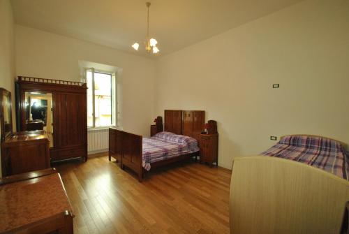 カスティリョンチェッロにあるVilletta Calettaのウッドフロアのベッドルーム1室(ベッド2台、窓付)が備わります。