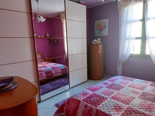 古斯皮尼的住宿－Bilocale La Genuina，一间带镜子、一张床和一张桌子的卧室