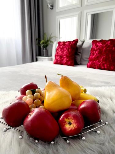 a plate of fruit on a bed with a bed at Apartment Studio PARIS 92 in Irpin'