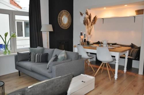 uma sala de estar com um sofá e uma sala de jantar em Sunny Reef em Egmond aan Zee