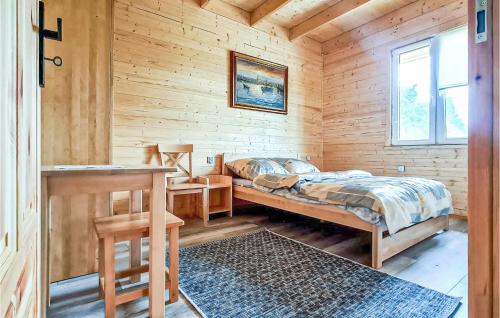 a bedroom with a bed in a wooden cabin at 2 Bedroom Beautiful Home In Gizycko in Giżycko