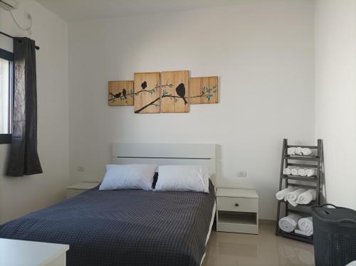 um quarto com uma cama e um quadro na parede em נוגה בגולן em Katzrin