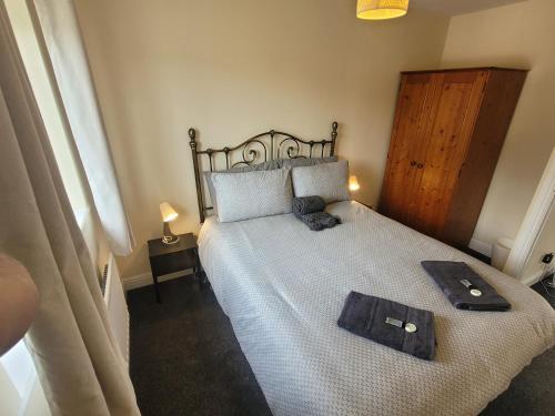 a bedroom with a bed with two towels on it at Lovely 2 bed appt with parking only 5 mins from M6 or Carlisle in Carlisle
