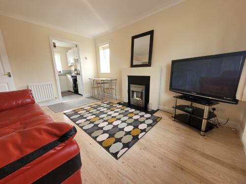 a living room with a fireplace and a television at Lovely 2 bed appt with parking only 5 mins from M6 or Carlisle in Carlisle