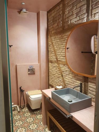 a bathroom with a sink and a mirror and a toilet at Libretto Suites in Lefkada Town