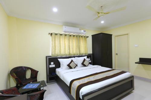 a bedroom with a large bed and a chair at HOTEL SAl INN - NEAR AIRPORT in Chennai