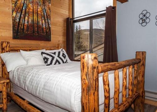une chambre avec un lit en bois et une fenêtre dans l'établissement Flying Dutchman by Summit County Mountain Retreats, à Keystone