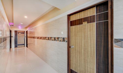 a hallway with a wooden door in a house at HOTEL SAl INN - NEAR AIRPORT in Chennai