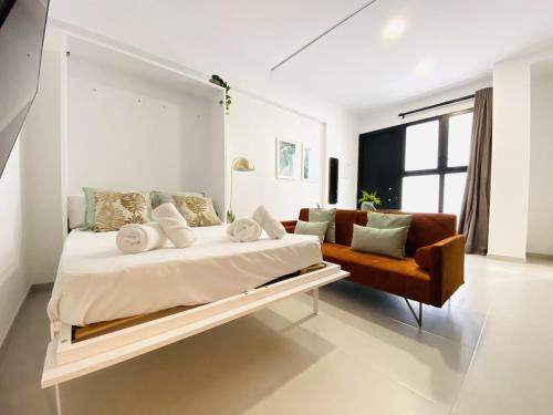 a white bedroom with a large bed and a couch at RUBEN VELA - LOFT CLOSE to RUSSAFA (SOHO) in Valencia