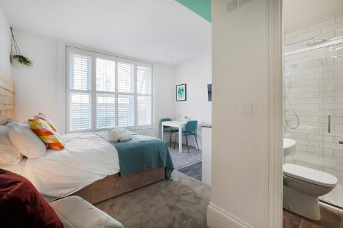 a bedroom with a bed and a bathroom with a toilet at Stylish Eco-Friendly Apartments in Folkestone in Folkestone