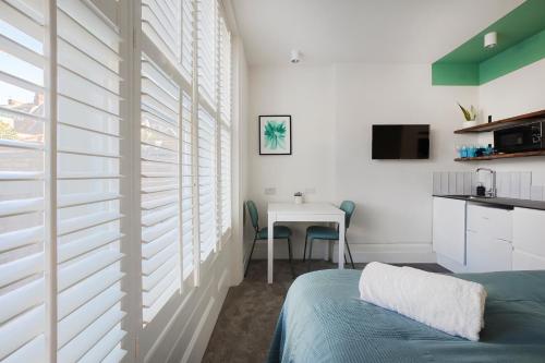 a bedroom with white walls and a table with a bed at Stylish Eco Aparthotel in Folkestone in Folkestone