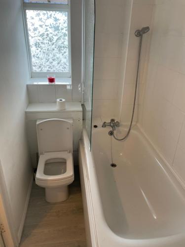 baño con aseo, bañera y ventana en one bedroom flat near Vauxhall train station London en Londres