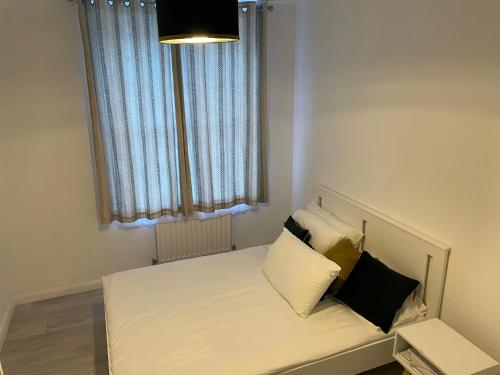 um pequeno quarto com uma cama com almofadas em one bedroom flat near Vauxhall train station London em Londres