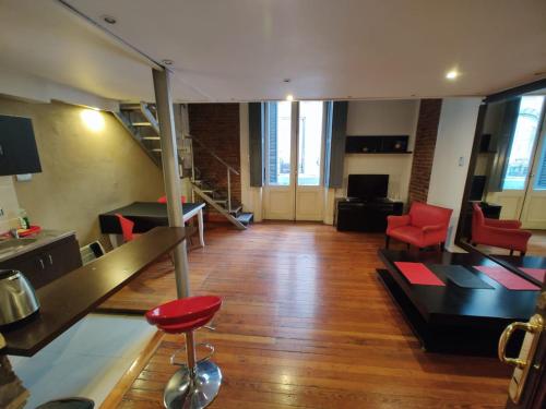 a large living room with red chairs and a table at Hermoso Loft Centrico in Buenos Aires