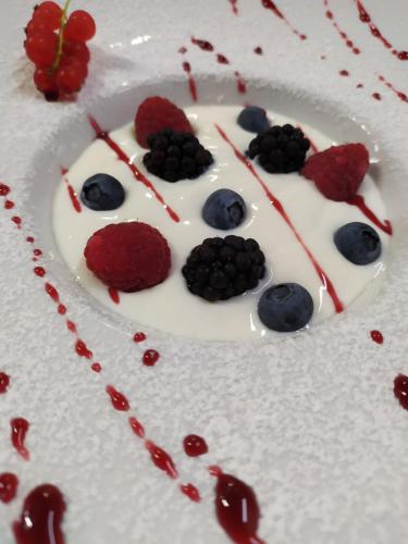 a dessert in the shape of a face with berries on it at Albergo Ristorante Cacciatori in Auronzo di Cadore