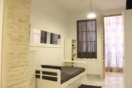 mała sypialnia z łóżkiem i oknem w obiekcie Amazing Sevilla Apartamento w Sewilli