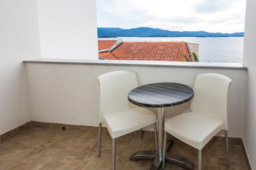 a table and chairs in a balcony with a view of the water at Holiday Home in Komarna
