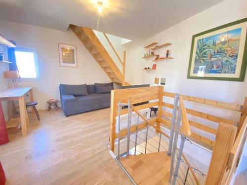 - un salon avec un canapé bleu et un escalier dans l'établissement - Le Lys - Magnifique maisonnette avec terrasse, à Poitiers